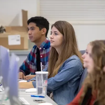 Students listening attentively in a classroom.