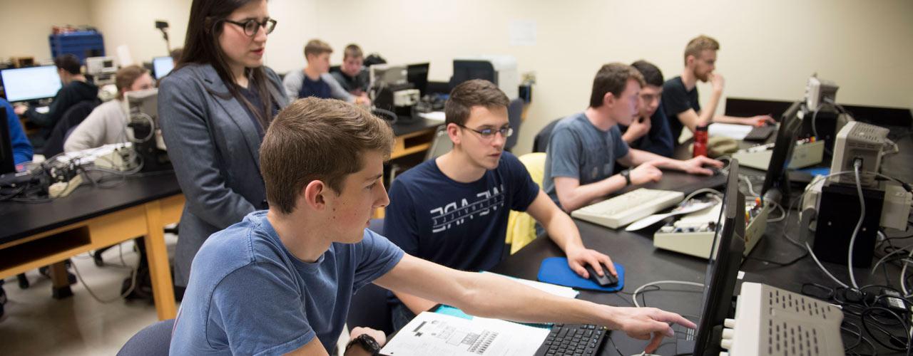 Dr. Danielle Fredette and students looking at computers