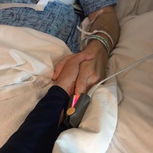 Dr. 迈克尔·麦凯 and his wife, Lee-Ann, hold hands after the surgery