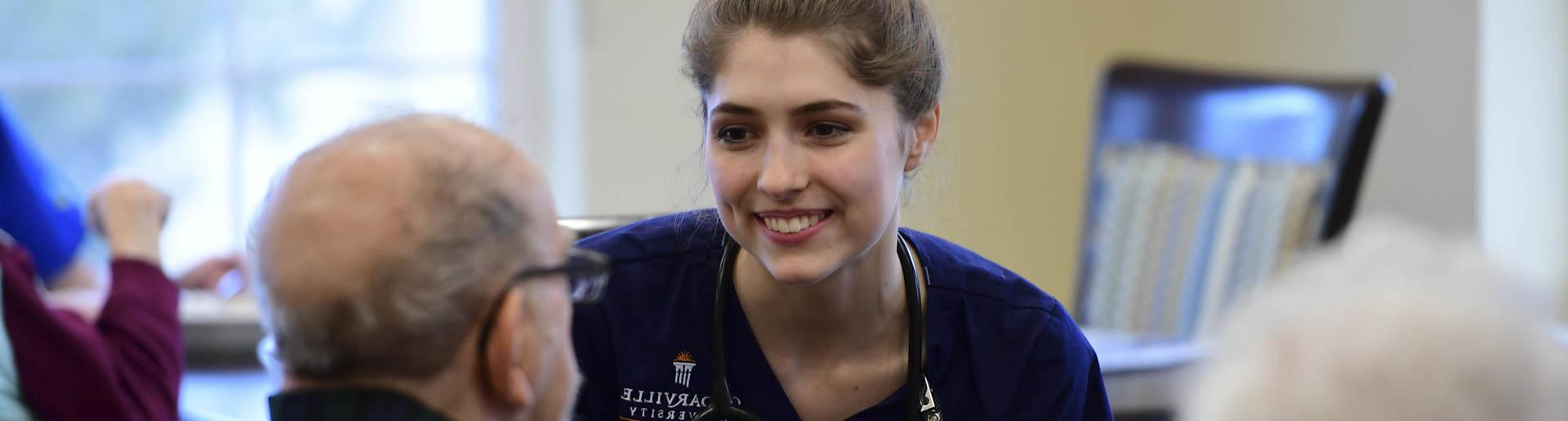 A Cedarville University nursing student interacts with an elderly man during clinicals.