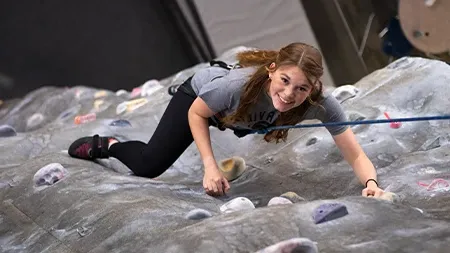 Student climbing climbing wall