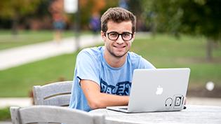 Male student using Apple laptop