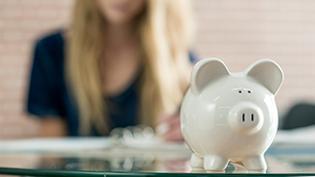 A white piggy bank sits on a table