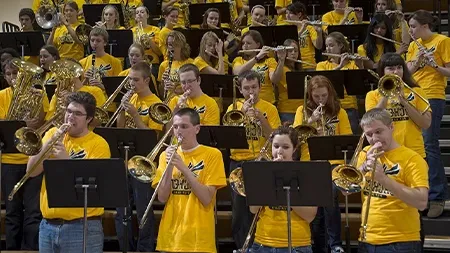 Large group of students playing instruments at basketball game